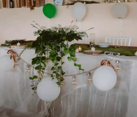 Széppatak Farm vidéki esküvői helyszín pajtájában feldíszített asztal az ifjú párnak.